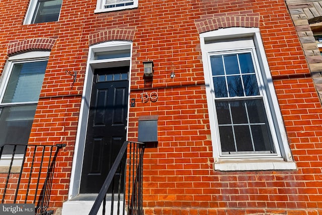 doorway to property featuring brick siding