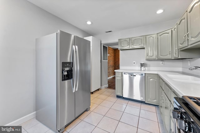 kitchen featuring light tile patterned floors, stainless steel appliances, recessed lighting, light countertops, and a sink