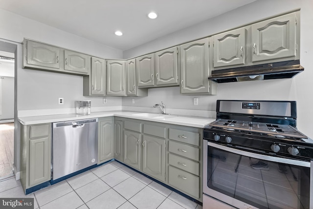 kitchen with a sink, under cabinet range hood, stainless steel appliances, and light countertops