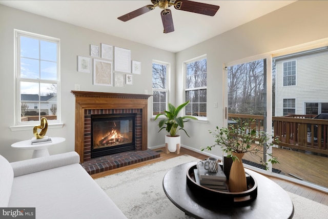 interior space with a brick fireplace, wood finished floors, and baseboards