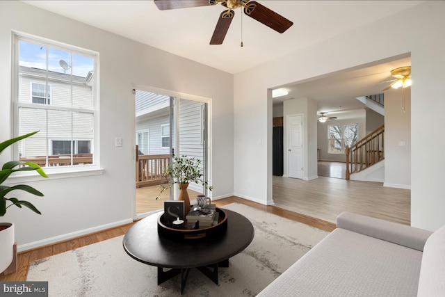 sitting room featuring stairs, baseboards, and light wood-style floors