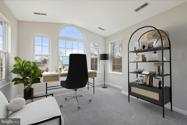 office space featuring carpet floors, visible vents, and vaulted ceiling