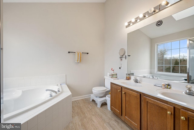 bathroom featuring double vanity, a sink, toilet, and a bath