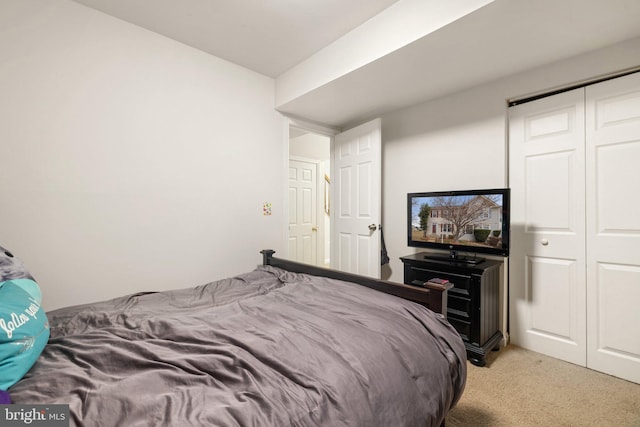 bedroom with a closet and light colored carpet