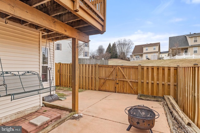 view of patio featuring a gate, fence, and a fire pit