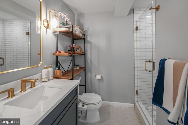 bathroom featuring toilet, a shower stall, vanity, tile patterned flooring, and baseboards