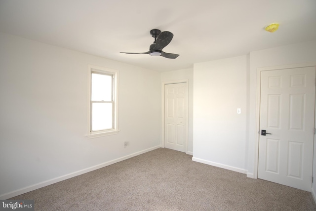 unfurnished bedroom featuring carpet, a closet, ceiling fan, and baseboards