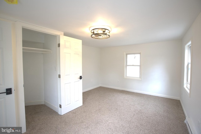 unfurnished bedroom with a spacious closet, a closet, carpet, and baseboards