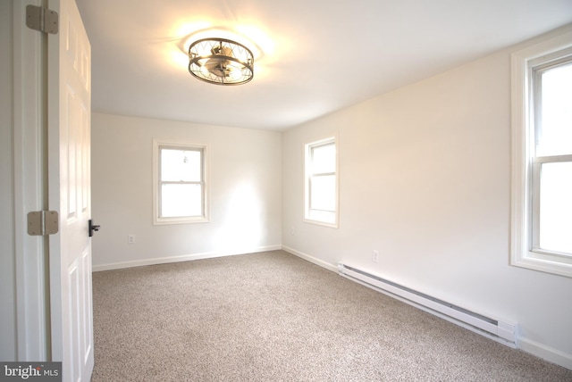 carpeted empty room featuring baseboards, baseboard heating, and a wealth of natural light