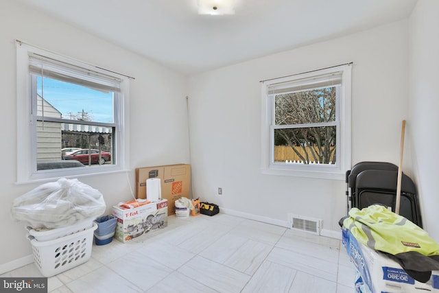 interior space featuring tile patterned flooring, visible vents, and baseboards