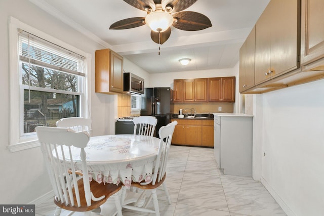 kitchen featuring a sink, baseboards, marble finish floor, brown cabinetry, and stainless steel microwave