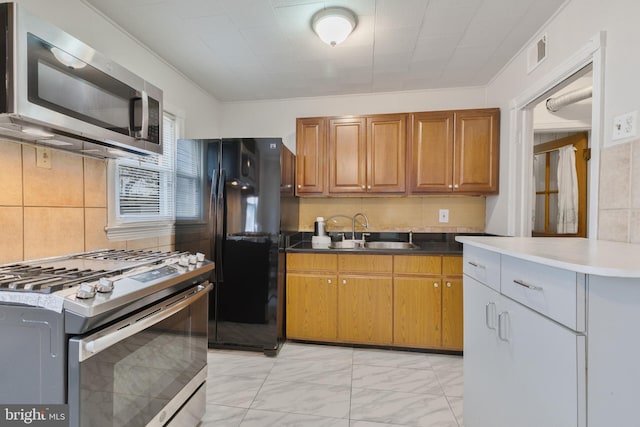 kitchen featuring a sink, visible vents, appliances with stainless steel finishes, brown cabinets, and decorative backsplash