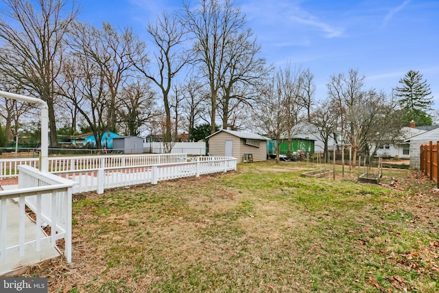 view of yard with a fenced backyard, a swimming pool, a shed, and an outdoor structure