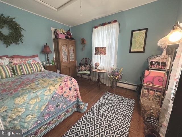 bedroom featuring a baseboard heating unit and wood finished floors