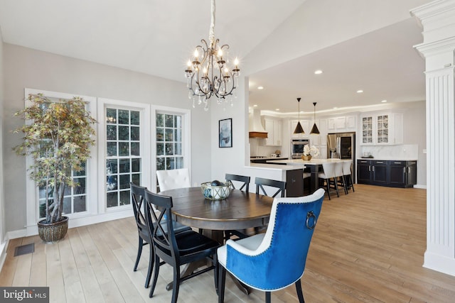 dining room featuring light wood-style floors, visible vents, vaulted ceiling, and recessed lighting