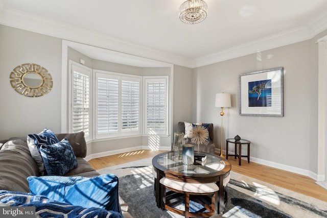 living area with ornamental molding, wood finished floors, and baseboards