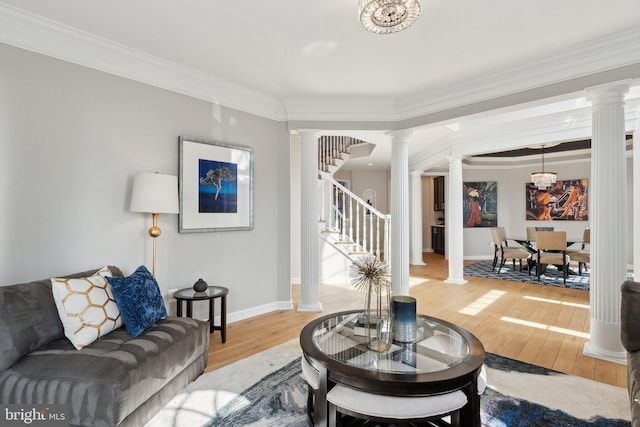 living area featuring stairs, wood finished floors, and ornate columns