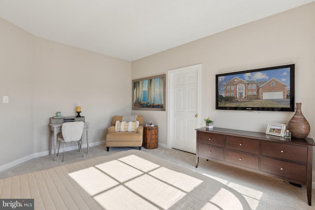 living area featuring light colored carpet and baseboards