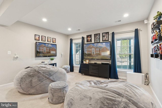 living area featuring light colored carpet, visible vents, baseboards, and recessed lighting