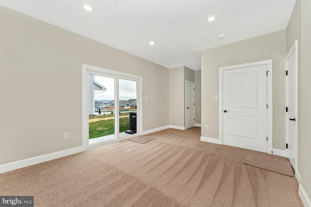 interior space featuring recessed lighting, baseboards, and light colored carpet