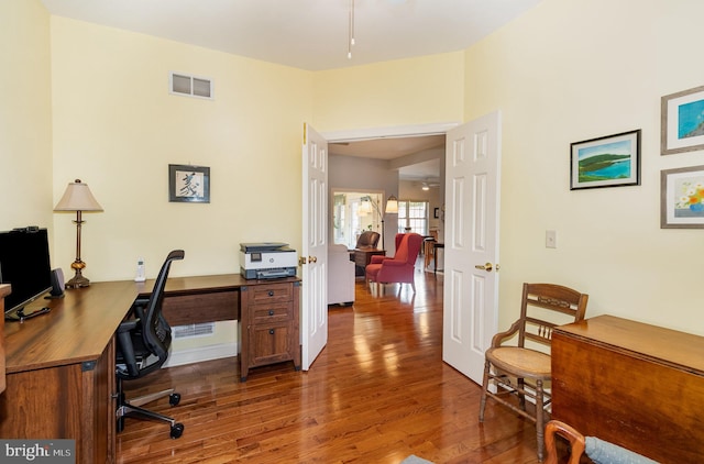 home office featuring visible vents and wood finished floors