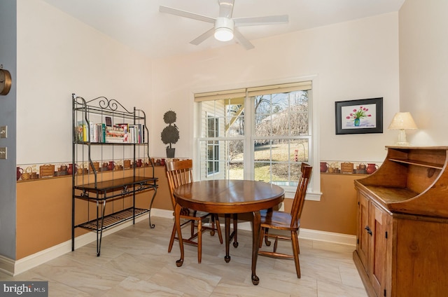 dining area featuring ceiling fan and baseboards