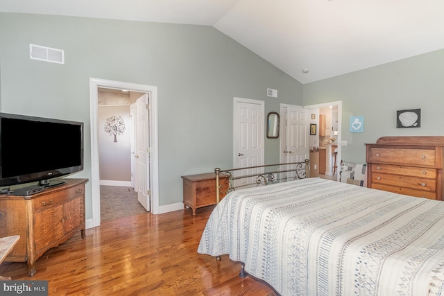 bedroom featuring high vaulted ceiling, baseboards, visible vents, and wood finished floors