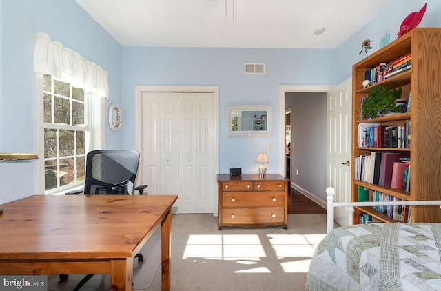 bedroom featuring light carpet, visible vents, and a closet