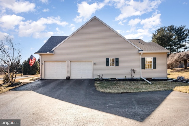 view of property exterior with aphalt driveway, a shingled roof, and an attached garage