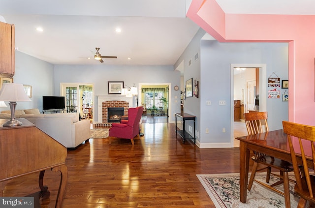 living room with recessed lighting, dark wood-type flooring, a brick fireplace, ceiling fan, and baseboards