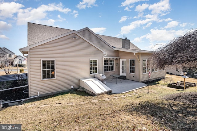 back of property with a garden, a patio, a chimney, roof with shingles, and a yard