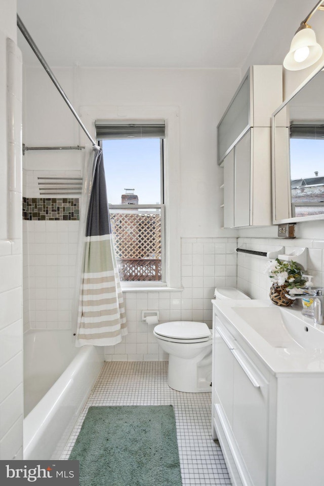 bathroom with toilet, vanity, tile walls, tile patterned floors, and shower / bathtub combination with curtain