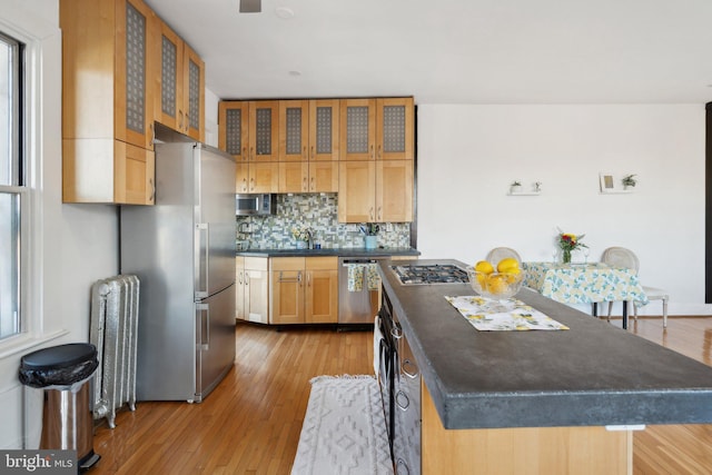 kitchen featuring stainless steel appliances, dark countertops, and glass insert cabinets