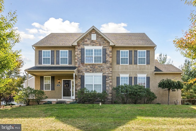 view of front of house featuring stucco siding, roof with shingles, stone siding, and a front yard