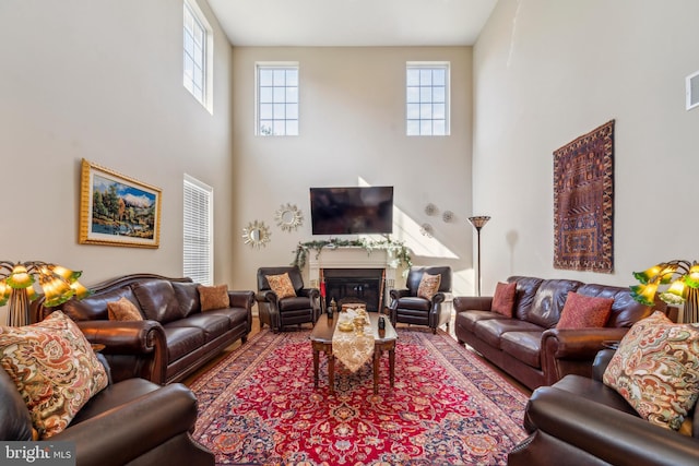 living area featuring a glass covered fireplace and visible vents