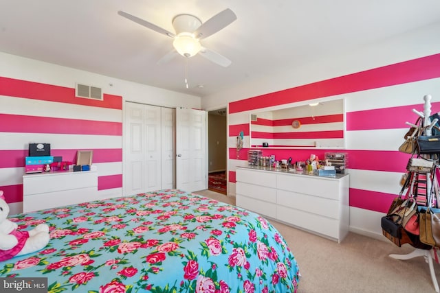 bedroom featuring light carpet, a closet, visible vents, and a ceiling fan