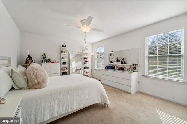 bedroom featuring ceiling fan, baseboards, and light colored carpet