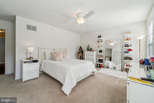 bedroom featuring light carpet, visible vents, and a ceiling fan