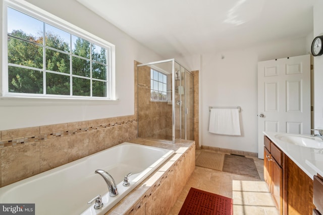 full bathroom with a garden tub, tile patterned flooring, vanity, baseboards, and a shower stall