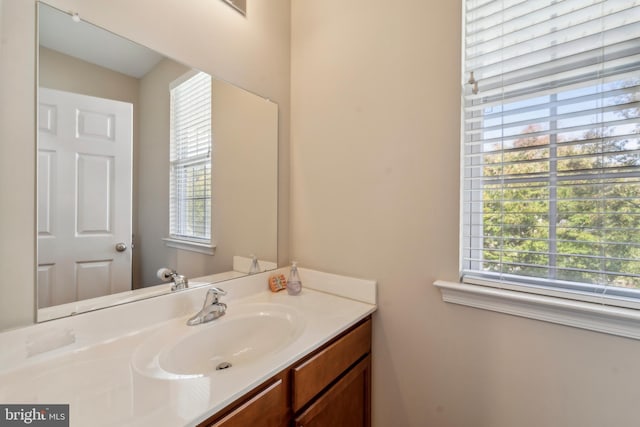 half bathroom featuring a wealth of natural light and vanity