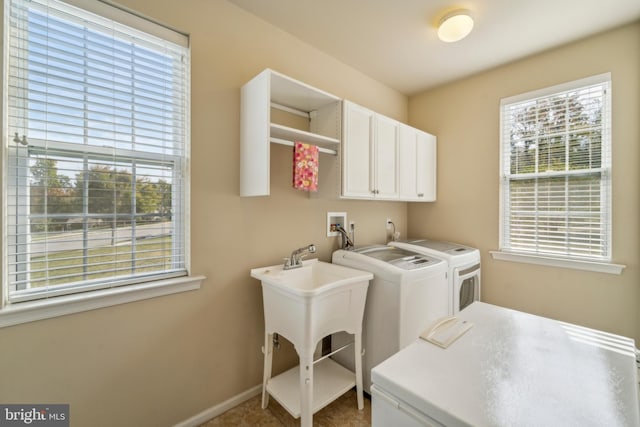 laundry room with washer and clothes dryer, cabinet space, and baseboards