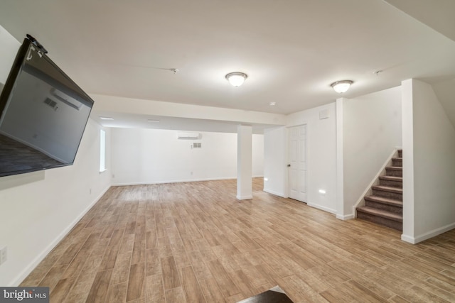 finished below grade area featuring light wood-style floors, stairs, and baseboards