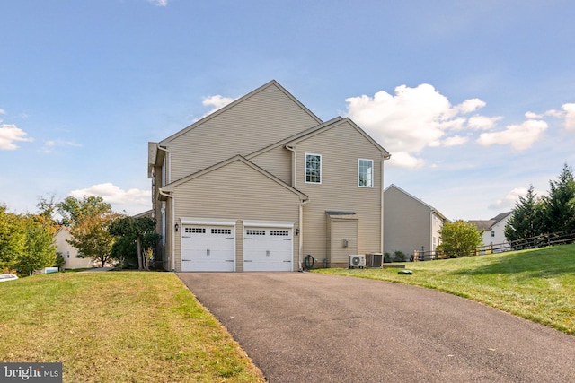 view of front of house with driveway, a garage, cooling unit, and a front yard