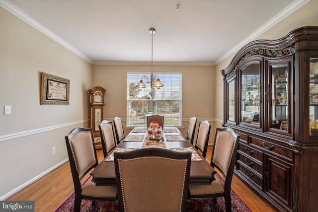 dining space with crown molding, baseboards, and wood finished floors