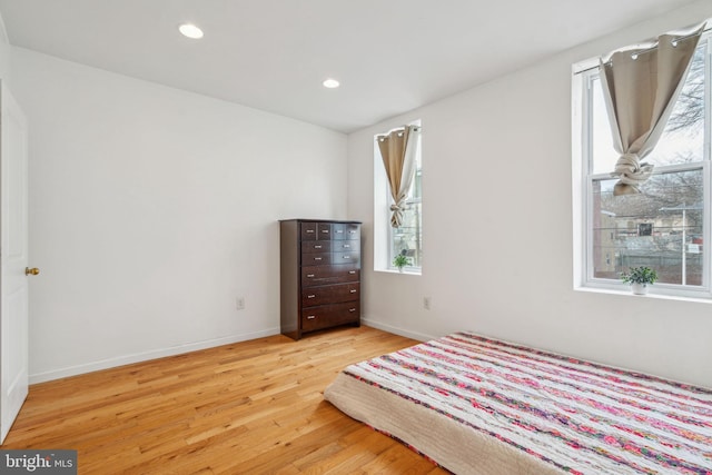 unfurnished bedroom featuring baseboards, light wood finished floors, and recessed lighting