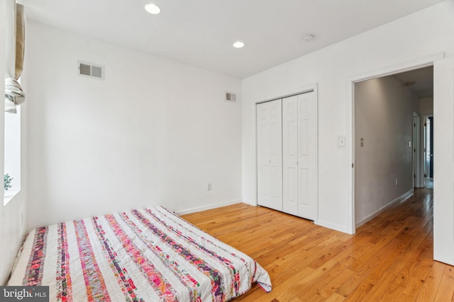 bedroom with recessed lighting, visible vents, baseboards, and wood finished floors