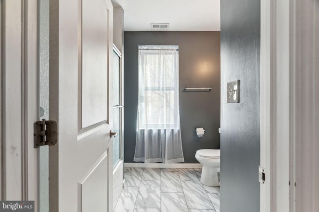 bathroom featuring toilet, marble finish floor, visible vents, and baseboards