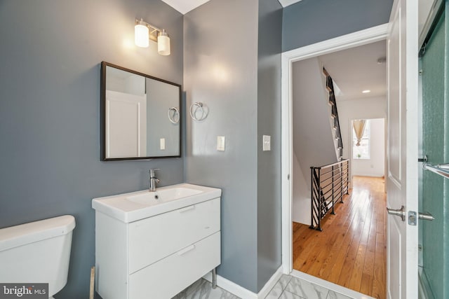 bathroom with toilet, baseboards, and vanity