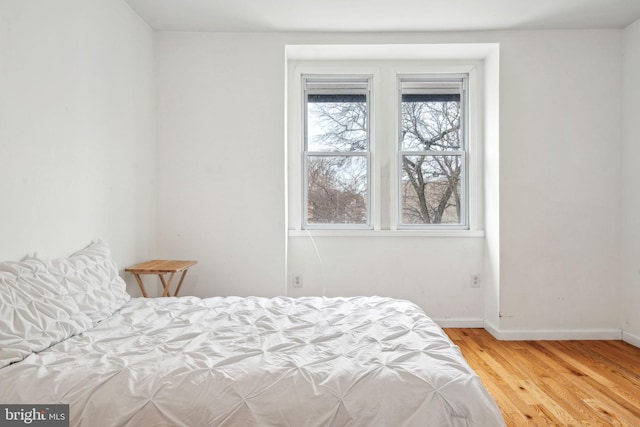 bedroom featuring baseboards and wood finished floors