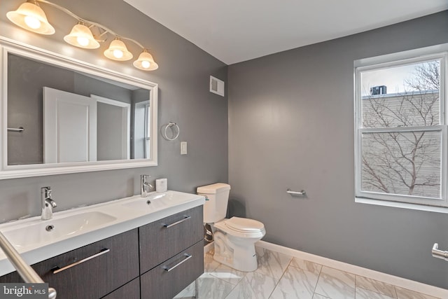 bathroom featuring marble finish floor, visible vents, a sink, and baseboards